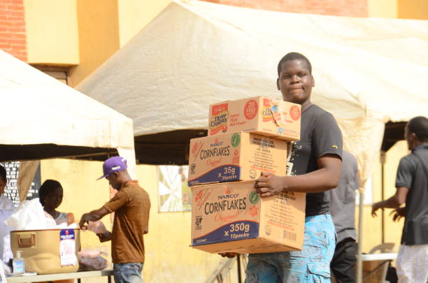 A boy carrying cartones of food items after shopping at a Primary School converted for a temporary makeshift food market established by Lagos State government for residents of the Ifako Ijaye community in Lagos on April 3, 2020. The Nigerian government has approved the establishment of temporary makeshift food markets in states where a lockdown was imposed, to contain the spread of COVID-19 coronavirus, by Nigerian President Mohammadu Buhari to cushion the effect of a two-week lockdown. (Photo by Olukayode Jaiyeola/NurPhoto via Getty Images)