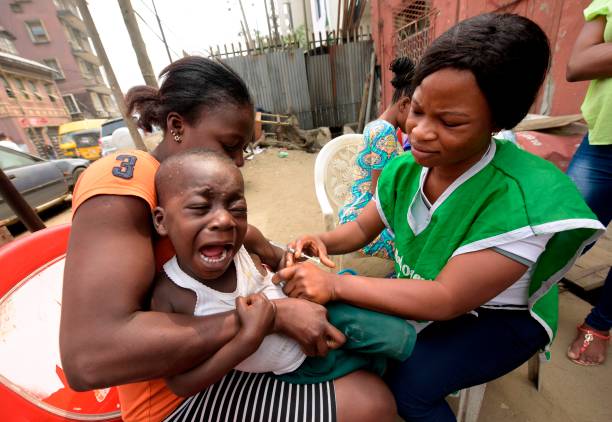 A young boy reacts as a health worker administers a measles vaccine in Lagos on January 29, 2016. 
Bill Gates and the Dangote Foundations in Abuja on January 20 announced a special partnership deal to fight the menace of malnutrition ravaging some children in northern Nigeria. "The partnership will commit the sum of 100 million dollars to addressing malnutrition in Nigeria between now and 2020," Dangote said.  / AFP PHOTO / PIUS UTOMI EKPEI        (Photo credit should read PIUS UTOMI EKPEI/AFP via Getty Images)